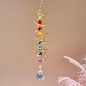 Detailed view of golden spiral wind spinner with colorful beads and a crystal ball pendant