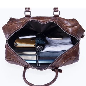Top-down view of a spacious brown leather travel bag showing organized interior storage