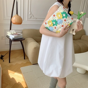 Lifestyle shot of a floral cotton makeup bag held by a model in a French interior