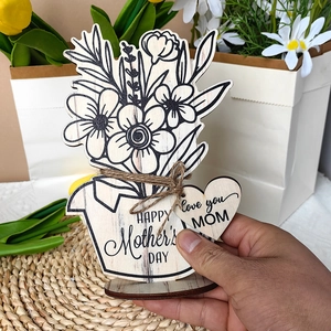Macro shot of wooden flower pot ornament with Happy Mother's Day engraving and love heart tag