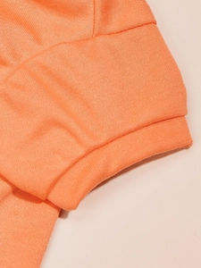 Close-up of coral orange pet t-shirt showing high-quality stitching and cotton fabric