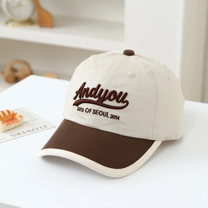Dettaglio del ricamo Andyou su un berretto da baseball bicolore beige e marrone elegante