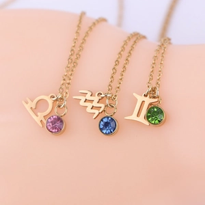 Detailed macro view of three golden zodiac necklaces with colorful round cubic zirconia