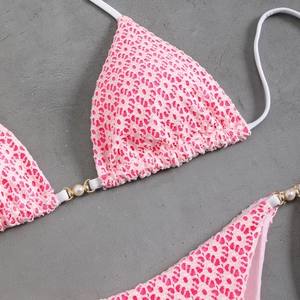 Detail of pink leopard print bikini with 3D texture, pearl accents and gold metal rings