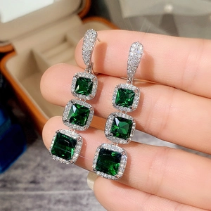 Detailed view of silver square emerald green zircon drop earrings with halo micro-pave crystals