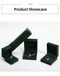 Deep green velvet jewelry boxes displaying silver snake bracelet and diamond necklace