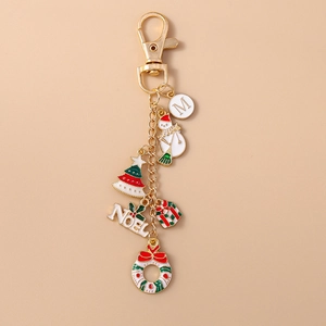 Christmas keychain detail with letter M, snowman, tree and wreath on gold metal chain