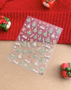 Close-up of Christmas nail stickers with gold gingerbread man and snowflake patterns