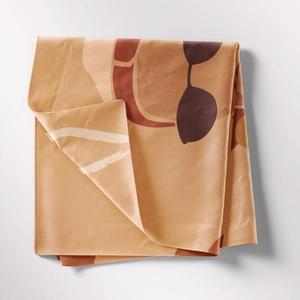 Close-up of bohemian tapestry fabric showing abstract portrait print and fine edge stitching
