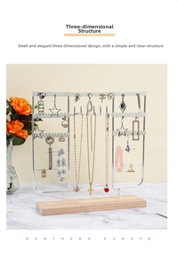 Detail of metal jewelry stand with wooden base displaying various necklaces and earrings