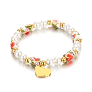 Bracelet perles vintage avec perles de résine fleuries et pendentif coeur doré sur blanc