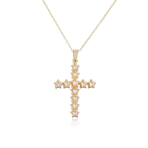 Macro d'un collier plaqué or 18K avec pendentif croix en zircon rose sur fond blanc pur