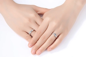 Close-up of minimalist couple rings with crown zircon on interlocking hands