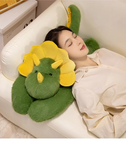 Asian model relaxing on a sofa with a soft green triceratops plush dinosaur pillow