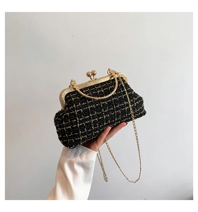 Detail of black tweed crossbody bag with gold metal frame and double ball clasp