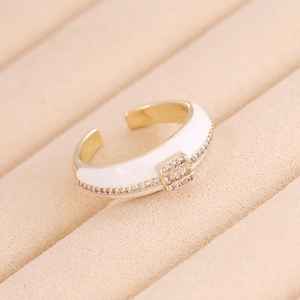Macro di anello geometrico placcato oro con smalto bianco e zirconi in astuccio di velluto