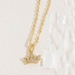 Macro shot of gold crown pendant with micro-pave cubic zirconia on a fine link chain
