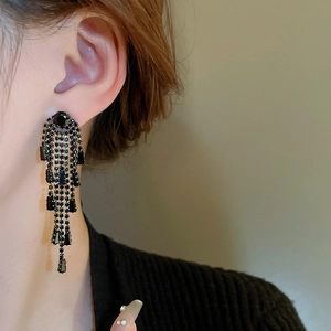 Gros plan de boucles d'oreilles à franges de strass noirs avec gouttes de cristal