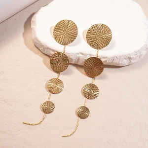 Metallic tiered circular drop earrings with geometric textured gold discs on a stone base