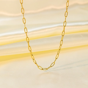Bracelet chaîne trombone en or 18k poli élégamment présenté sur de la soie