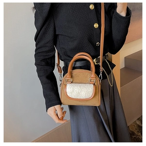 Detail of camel faux suede handbag with white faux shearling panel and silver hardware
