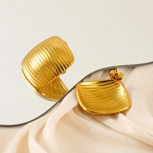 Detailed macro view of 18K gold plated square stud earrings with vertical ribbed texture