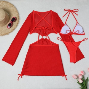 Flat lay view of a red three-piece mesh bikini set with long sleeve cover-up and accessories