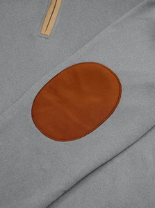 Detailed close-up of dark grey sweatshirt featuring brown oval elbow patches and knit texture