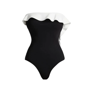 Détail d'un maillot de bain noir avec de grands volants blancs élégants au décolleté