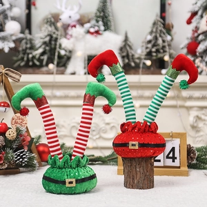 Christmas elf leg decor with red and green stripes on a festive tabletop with reindeer