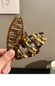 Detailed view of large tortoise shell acetate hair claws with premium marble patterns