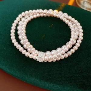Macro detail of elegant three-layer pearl bracelet with sparkling rhinestone clasp