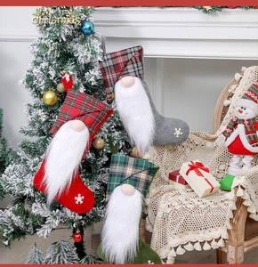 Three festive Christmas stockings with faceless gnomes hanging on a decorated tree