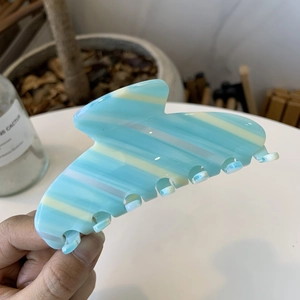 Blue and yellow striped acetate hair claw clip for women in a large shark fin design