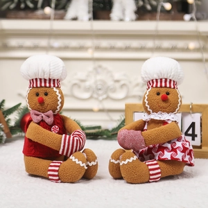 Christmas gingerbread man plush dolls in chef outfits standing by a festive fireplace