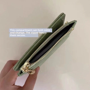 Detail view of a green faux leather wallet showing the zippered coin compartment inside
