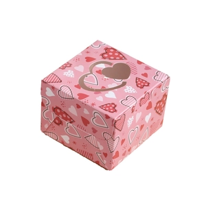 Pink square gift box with colorful heart patterns and golden heart-shaped cutout lid