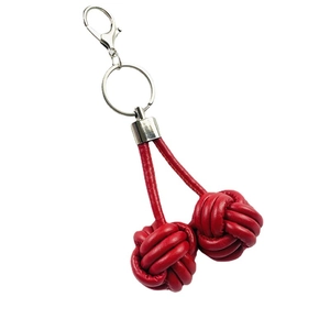 Handmade red leather woven ball keychain with monkey fist knot and spring clasp on white background