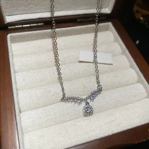Macro d'un collier pendentif cygne en zircon argenté dans un coffret à bijoux en bois