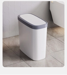Close-up of narrow slim trash can with press-top lid design in a modern bathroom