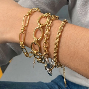 Golden stainless steel Cuban chain bracelet set of four styled on a female model