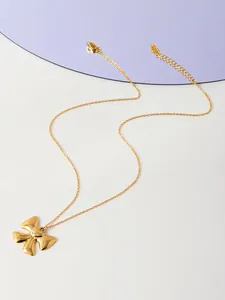 Gros plan détaillé d'un collier doré avec pendentif nœud, chaîne fine et fermoir mousqueton