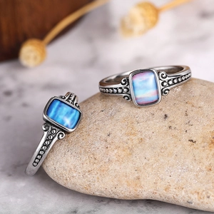 Detailed macro of vintage silver rings with rectangle gemstones on rustic stone background