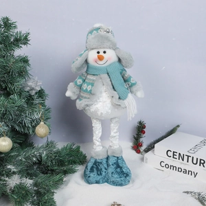 Detail of a standing Christmas snowman plush in light blue knitwear on snowy background