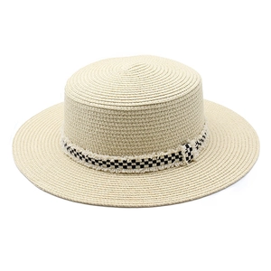 Détail du chapeau de paille beige avec ruban à damier et bordure effilochée
