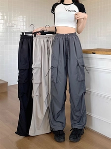 Detail showing loose fit cargo pants in grey, black, and beige with multi-pocket design
