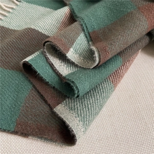 Close-up detail of green and brown plaid scarf showing thick wool texture and fringe