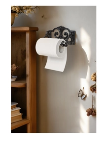 Detail of vintage cast iron wall mount paper towel holder with ornate scrollwork design