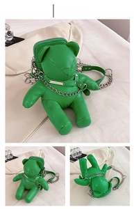 Detail view of a green bear-shaped PU leather crossbody bag with silver chain straps