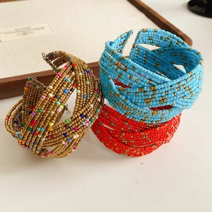 Gros plan de perles en verre colorées sur des bracelets bohèmes multicouches dorés
